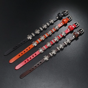 Vista dettagliata di bracciali in pelle con borchie a croce in nero, arancio e marrone