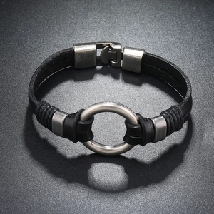 Détail d'un bracelet en cuir noir tressé avec anneau en argent vieilli et fermoir en métal