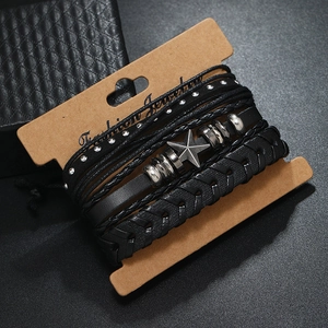 Detail of layered black leather bracelets with metallic stars and rivets on display card