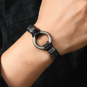 Détail de bracelet multicouche en cuir tressé noir avec anneau argenté au poignet