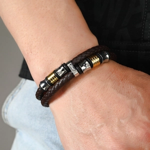 Détail d'un bracelet multicouche en cuir tressé marron avec perles en métal or et argent