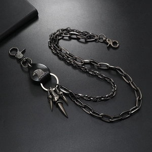 Detail einer Punk-Hosenkette mit Adler-Lederpatch und Metallanhängern im Grunge-Stil