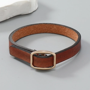 Detailansicht eines braunen Vintage-Lederarmbands mit poliertem goldenem Metallverschluss