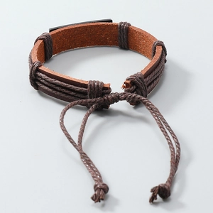 Detail view of woven leather bracelet with matte black metal plate and adjustable cord