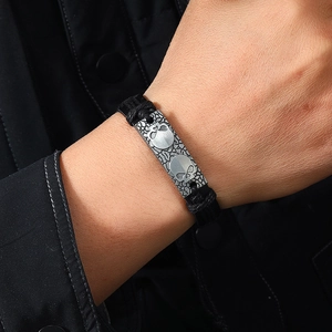 Punk woven leather bracelet featuring a silver skull metal plate on a male model's wrist