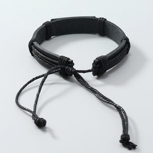 Detail of hand-woven black leather bracelet with adjustable cord and punk style metal accent