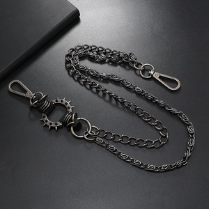 Detail of a multi-layer punk trouser chain with spikes on black textured background