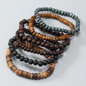 Close-up of stacked handmade wooden bead bracelets in various natural wood tones