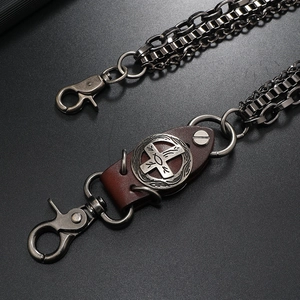 Detail of multi-layer gunmetal chain with leather cross emblem and lobster clasp