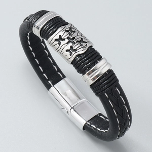 Détail d'un bracelet multicouche en cuir tressé avec breloques argentées et fermoir aimanté