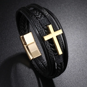 Detailed view of layered black braided leather bracelet with golden cross and magnetic clasp