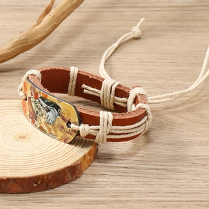 Close-up of adjustable leather bracelet with woven rope and vintage skull totem graphic