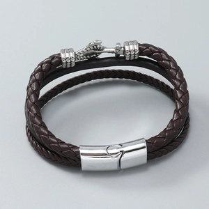 Detail of dark brown multi-layer braided leather bracelet with silver dragon spine charm