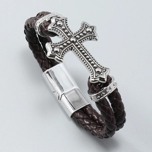 Close-up of brown braided leather bracelet featuring a silver cross with relief texture