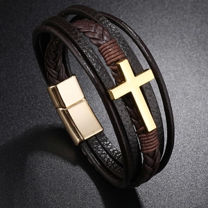 Detail of multi-layer brown leather bracelet with golden cross and magnetic clasp