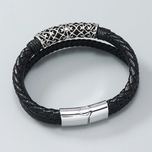 Macro detail of men's multilayer braided leather bracelet with silver magnetic metal clasp