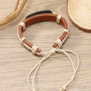 Detail of adjustable handmade woven leather bracelet with vintage totem pattern