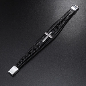 Detailed view of black woven leather layers with a silver cross and magnetic buckle