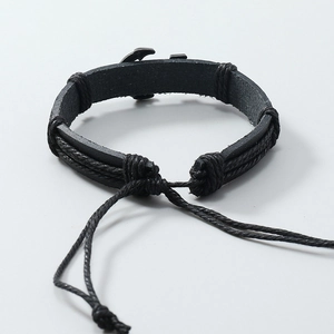 Detail of adjustable black leather braided bracelet with vintage nautical anchor metal charm