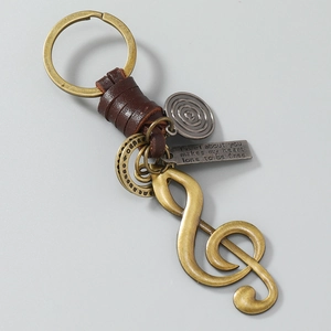 Macro detail of music note charms and engraved metal plate on a vintage keychain