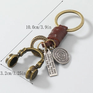 Vintage leather keychain with bronze headphone charm and engraved metal tag detail