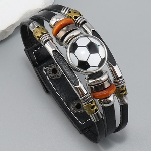 Detalle de una pulsera multicapa de cuero con tema de fútbol y colgantes de bronce