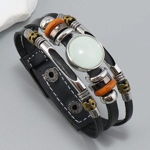 Detalle de pulsera de cuero trenzado multicapa con amuleto de calavera y cuenta turquesa