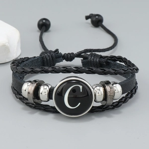 Detail of layered black leather bracelet with silver beads and letter C charm