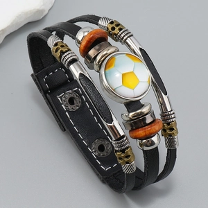 Detalle del brazalete de fútbol de cuero multicapa con costuras blancas y cuentas metálicas