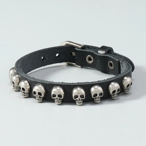 Détail d'un bracelet punk en cuir noir avec clous tête de mort et boucle métallique