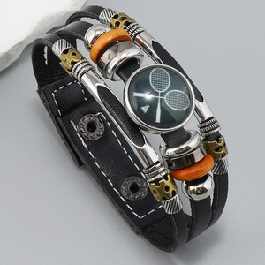 Detalle de pulsera de cuero multicapa con diseño de raquetas de tenis cruzadas