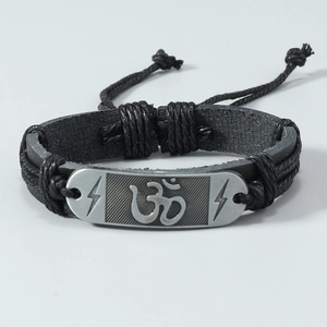 Gedetailleerde weergave van zwart gevlochten leren armband met metalen Om-symbool