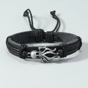 Detailed view of antique silver octopus charm on a black braided leather bracelet