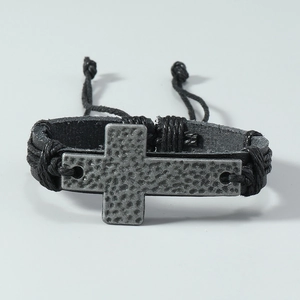 Close-up of retro leather bracelet showing the hammered metal cross and woven details