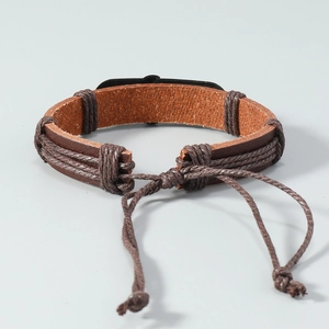 Detail of handmade brown leather beach bracelet with adjustable woven rope closure
