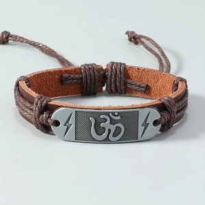 Detail van vintage meerlagige leren armband met gegraveerd Om-symbool en metalen plaat