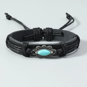 Détail d'un bracelet en cuir tressé vintage avec incrustation turquoise et cordon réglable