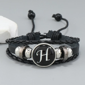 Detail of multi-layer braided leather bracelet with letter H and adjustable rope