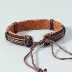 Détail du bracelet en cuir marron tressé avec cordon réglable et texture de la sangle