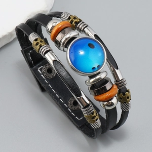 Detalle macro de pulsera de cuero trenzado con cuenta de vidrio azul y calavera