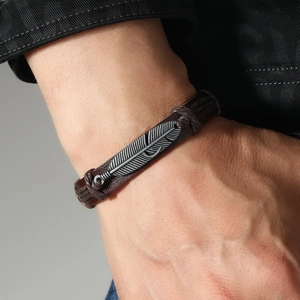 Bracelet en cuir marron tressé à la main avec un pendentif plume en argent de style rétro