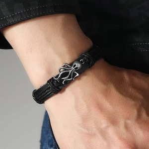 Detail showing hand-woven leather layers with a vintage silver octopus charm on the wrist