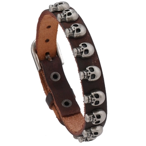 Bracelet punk en cuir marron foncé avec têtes de mort argentées et boucle ajustable