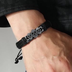Pulsera gótica de cuero trenzado negro para hombre con calaveras plateadas