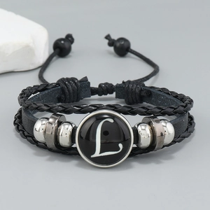 Detail view of multilayer braided leather bracelet with central round letter L glass charm