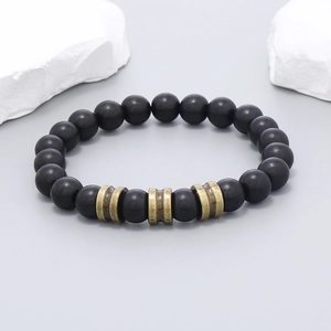 Vue macro de perles en bois noir mat avec des entretoises en bronze vintage sur le bracelet