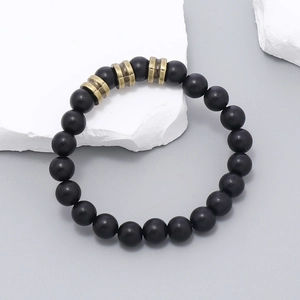 Vue détaillée de perles noires mates avec des intercalaires en métal bronzé