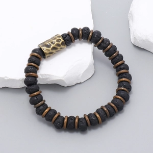 Macro detail of elastic lava stone bracelet with hammered bronze metal spacer beads