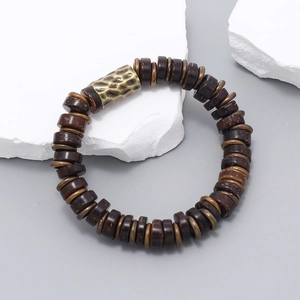 Detail of vintage coconut shell beaded bracelet with hammered metal cylinder accent