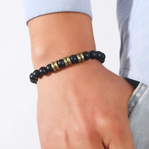 Bracelet rétro pour homme avec perles noires mates et intercalaires dorés sur le poignet